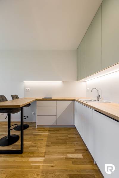 REZERVOVANÉ I METROPOLIS I Luxusný 1i byt I Staré Mesto - Kuchyňa v 1-izbovom byte s podlahou s dreveným dekorom a svetlým nábytkom.