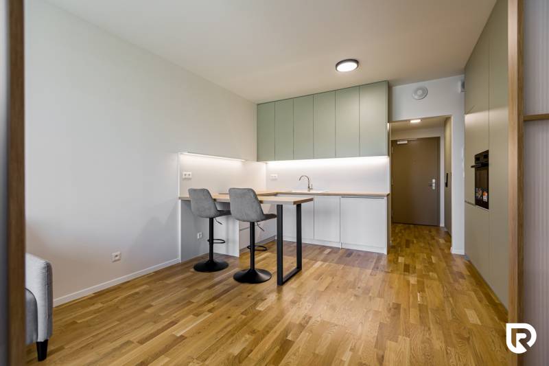 REZERVOVANÉ I METROPOLIS I Luxusný 1i byt I Staré Mesto - Kuchyňa s barovým pultom a podlahou s dreveným dekorom v 1-izbovom byte.