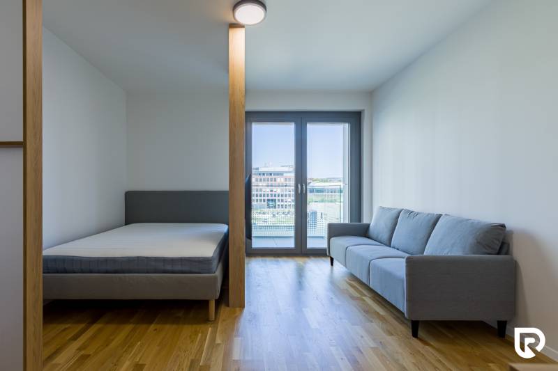 REZERVOVANÉ I METROPOLIS I Luxusný 1i byt I Staré Mesto - 1-izbový byt s posteľou, pohovkou a balkónovými dverami na podlahe s dreveným dekorom.