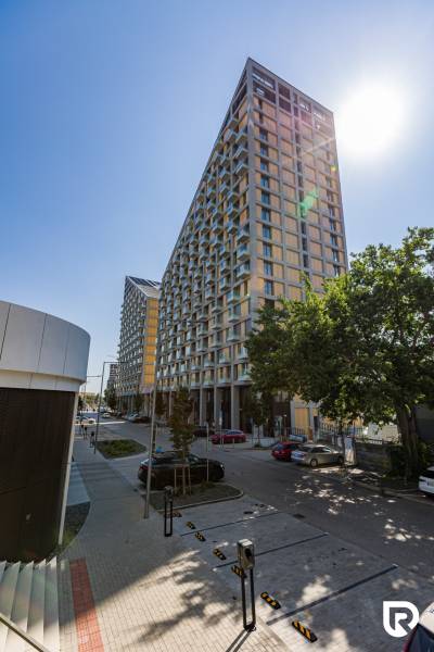 REZERVOVANÉ I METROPOLIS I Luxusný 1i byt I Staré Mesto - Výšková budova na Bottovej ulici v Bratislave - Starom Meste, s autami pozdĺž ulice.