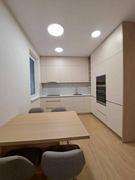 Prenájom: Lukratívny 2-izbový byt v Poprade na Novom nábreží - Kuchyňa v 2-izbovom byte s podlahou s dreveným dekorom a jednoduchým zariadením.