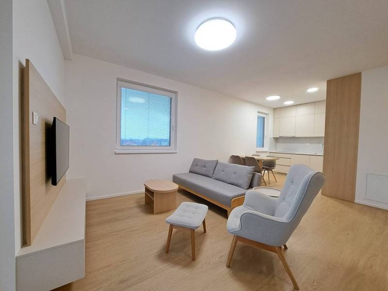 Prenájom: Lukratívny 2-izbový byt v Poprade na Novom nábreží - Obývačka v 2-izbovom byte s podlahou s dreveným dekorom a pohodlným sedením.