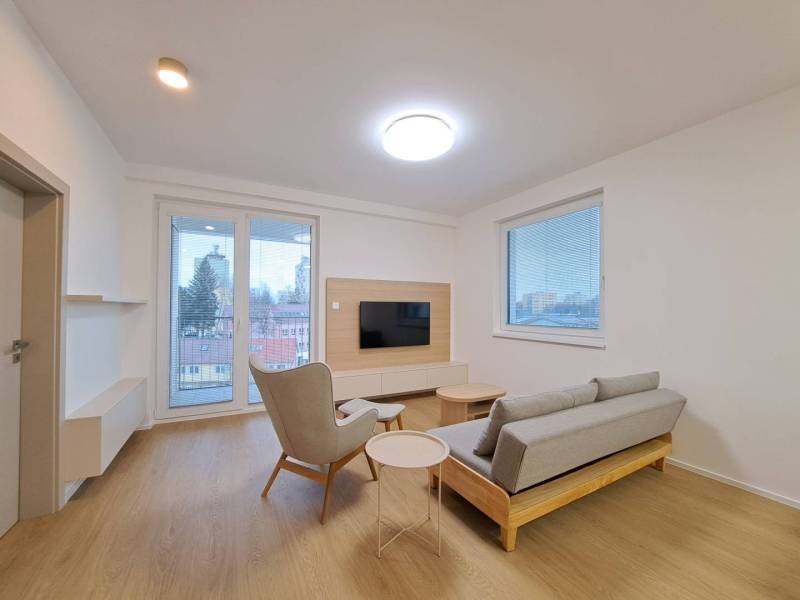 Prenájom: Lukratívny 2-izbový byt v Poprade na Novom nábreží - Obývacia izba v 2-izbovom byte s podlahou s dreveným dekorom, televíziou a výhľadom.