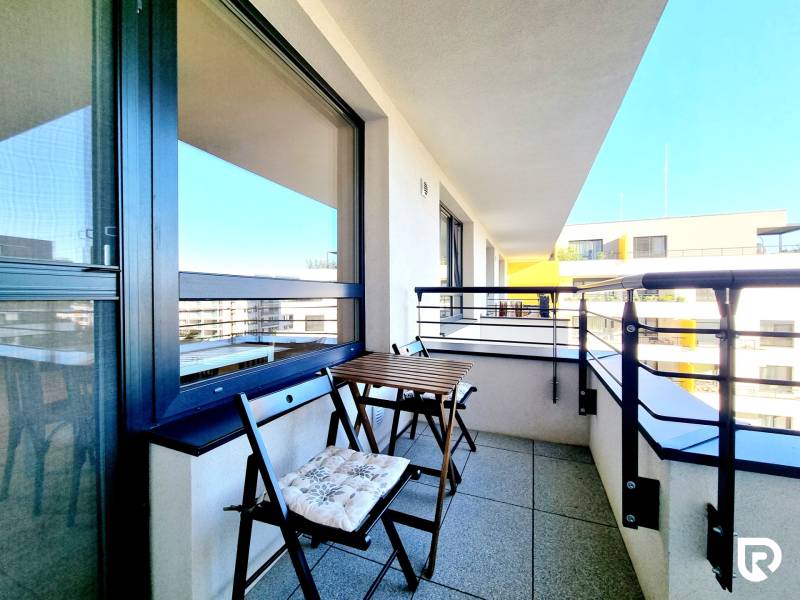 Pekný a moderný 3-izbový byt I Arboria Trnava - Balkón s malým dreveným stolom a stoličkami z 3-izbového bytu na Veterná v Trnave.