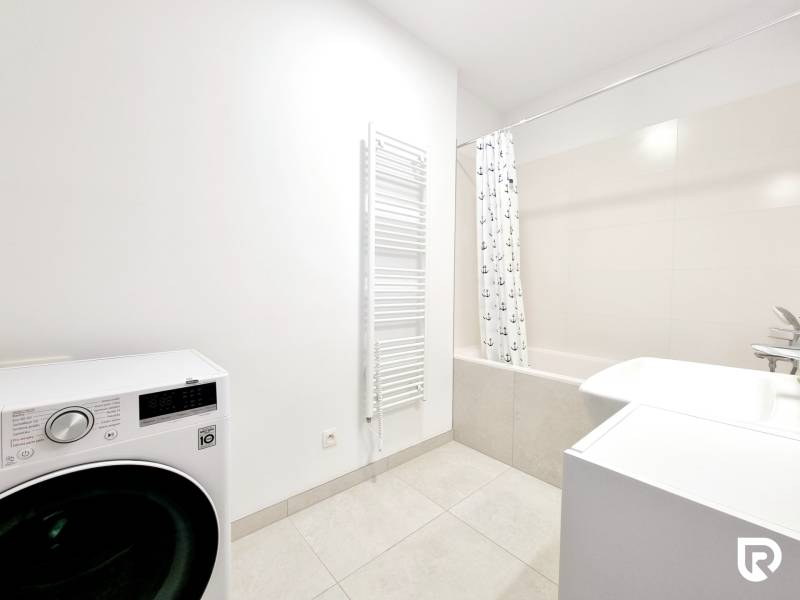 Pekný a moderný 3-izbový byt I Arboria Trnava - Kúpeľňa s práčkou, vaňou a svetlými obkladmi v 3-izbovom byte.