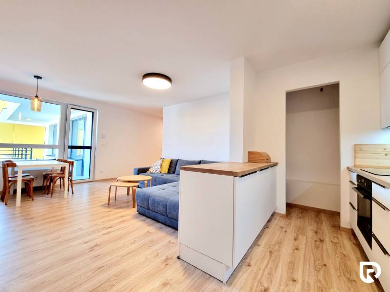 Pekný a moderný 3-izbový byt I Arboria Trnava - Interiér 3-izbového bytu s podlahou s dreveným dekorom, kuchyňou a balkónom.