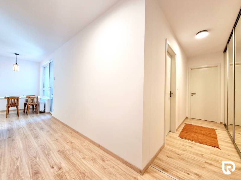 Pekný a moderný 3-izbový byt I Arboria Trnava - Chodba v 3-izbovom byte s podlahou s dreveným dekorom a jedálenským kútom.