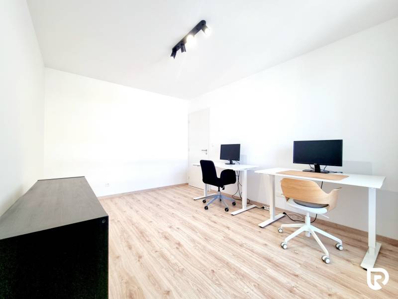 Pekný a moderný 3-izbový byt I Arboria Trnava - Kancelária v 3-izbovom byte s podlahou s dreveným dekorom, počítačmi a bielymi stolmi.