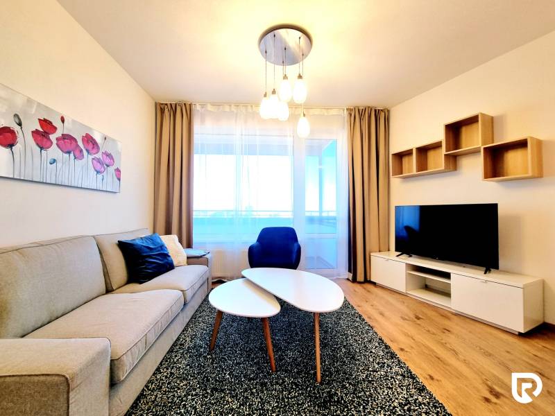 Posledný investičný krásny 2-izbový byt | 55 m² | RÍNOK RAČA - Obývačka v 2-izbovom byte s pohovkou, TV a podlahou s dreveným dekorom.