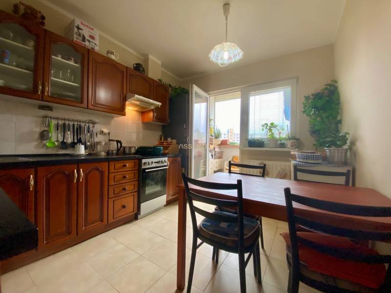 | PREDAJ | 3i byt s krásnym výhľadom vo vyhľadávanej časti BA - Kuchyňa v 3-izbovom byte s drevenými skrinkami, jedálenským stolom a oknom na balkón.