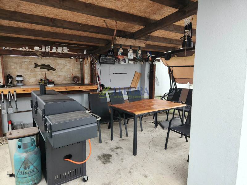 Na predaj dva rodinné domy Tornysnémeti HU - Zastrešené posedenie v rodinnom dome v Tornyosnémeti s grilom a stolom.