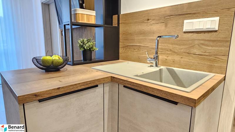 Moderný unikát - 1,5- izb. byt s 2 loggiami na prenájom (Nad jazerom) - Kuchynská linka v 1-izbovom byte s umývadlom a podlahou s dreveným dekorom.