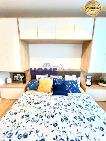 MODERNE A PRAKTICKY ZARIADENÝ 3 IZB. BYT V NOVOSTAVBE NA BOROCH. - Spálňa v 3-izbovom byte s podlahou s dreveným dekorom a kvetinovým obliečaním.