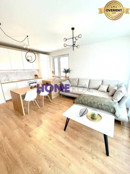 MODERNE A PRAKTICKY ZARIADENÝ 3 IZB. BYT V NOVOSTAVBE NA BOROCH. - Obývacia izba s kuchyňou v 3-izbovom byte, svetlá sedačka, podlaha s dreveným dekorom.