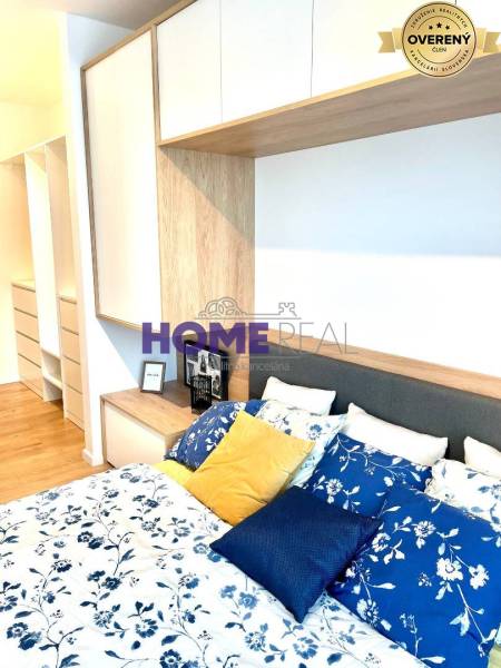 MODERNE A PRAKTICKY ZARIADENÝ 3 IZB. BYT V NOVOSTAVBE NA BOROCH. - Spálňa v 3-izbovom byte s posteľou, farebnými vankúšmi a úložnými priestormi.