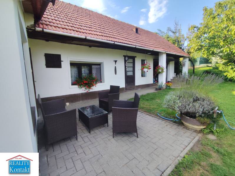 Ponúkame na predaj záhradný domček - Jasová - Rodinný dom v Jasovej s terasou, ratanovým nábytkom a upravenou záhradou.