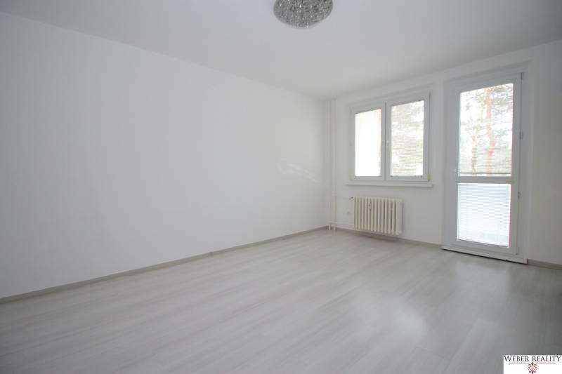 3-izb.byt v Dúbravke (Gallayova ul.) po rekonštrukcii s loggiou - Izba v 3-izbovom byte s podlahou s dreveným dekorom a veľkými oknami.