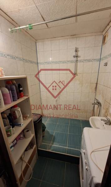 TOTO je Váš nový domov - 3 izbový byt Sereď  - Útulná kúpeľňa s práčkou, bielymi obkladačkami a poličkami, ideálna pre 3-izbový byt.