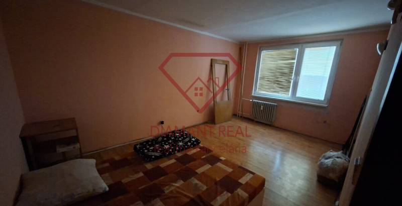 TOTO je Váš nový domov - 3 izbový byt Sereď  - Izba v 3-izbovom byte s podlahou s dreveným dekorom, jednoduché zariadenie.