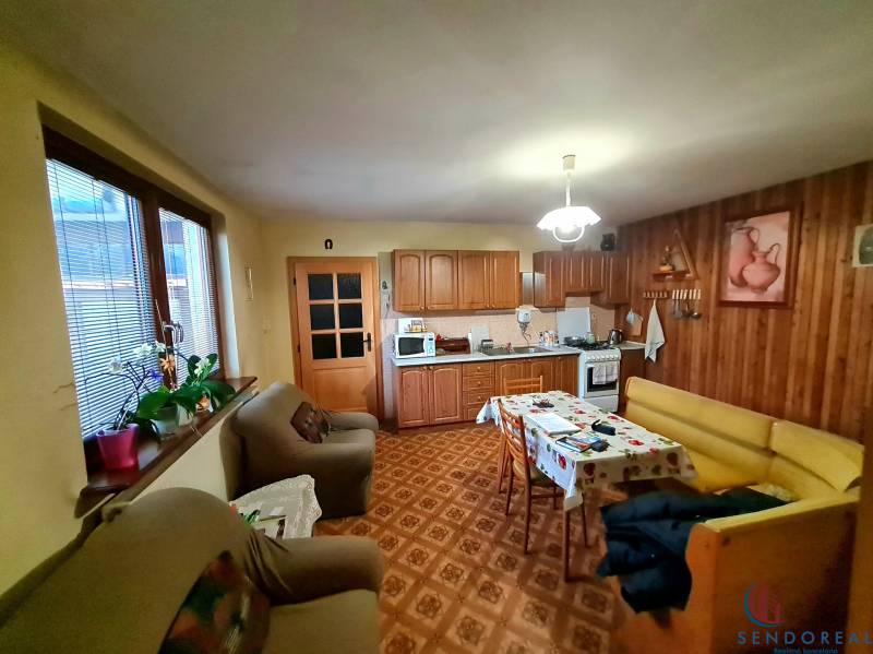 4.izb Rodinný Dom Centrum Chtelnica - Kuchyňa v rodinnom dome s dreveným dekórom, sedacou súpravou a jedálenským stolom.
