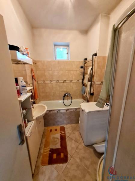 4.izb Rodinný Dom Centrum Chtelnica - Kúpeľňa s vaňou, umývadlom, práčkou a poličkami v rodinnom dome.