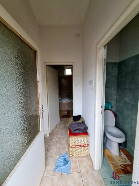 4.izb Rodinný Dom Centrum Chtelnica - Kúpeľňa a toaleta s dlažbou v rodinnom dome, s úložným košom.