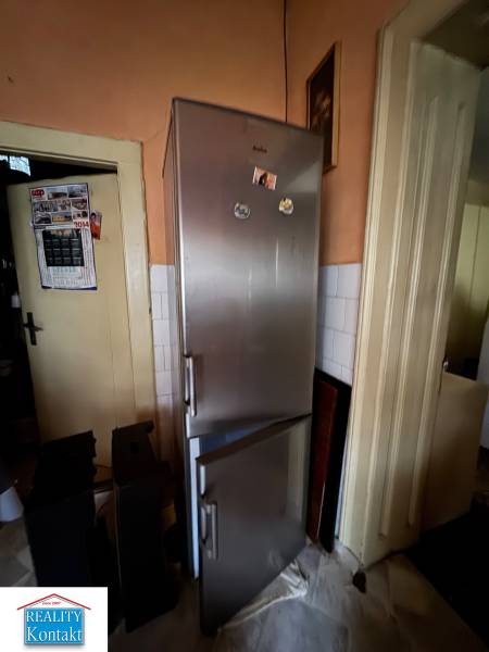 Predáme rodinný dom- Šurany, širšie centrum.  - Kuchyňa rodinného domu s chladničkou a kalendárom na stene.