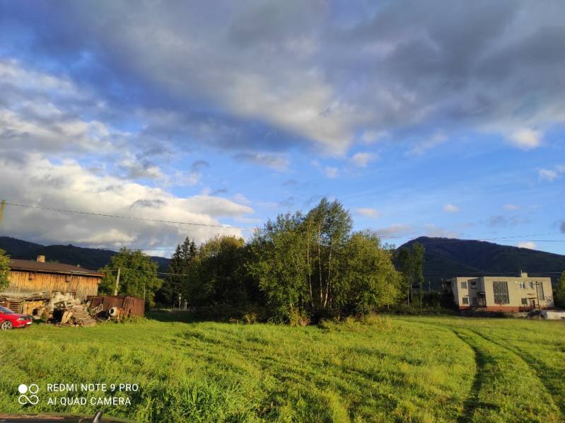 TURANY-stavebný pozemok o výmere 793 m2 - Zelená lúka, stromy, budova v pozadí, ideálna lokalita pre pozemky - bývanie.