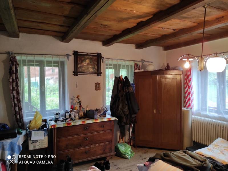 ČREMOŠNÉ-chalupa na pozemku 700m2   - Izba v rodinnom dome so starožitným nábytkom, dreveným stropom a rozličnými dekoráciami.