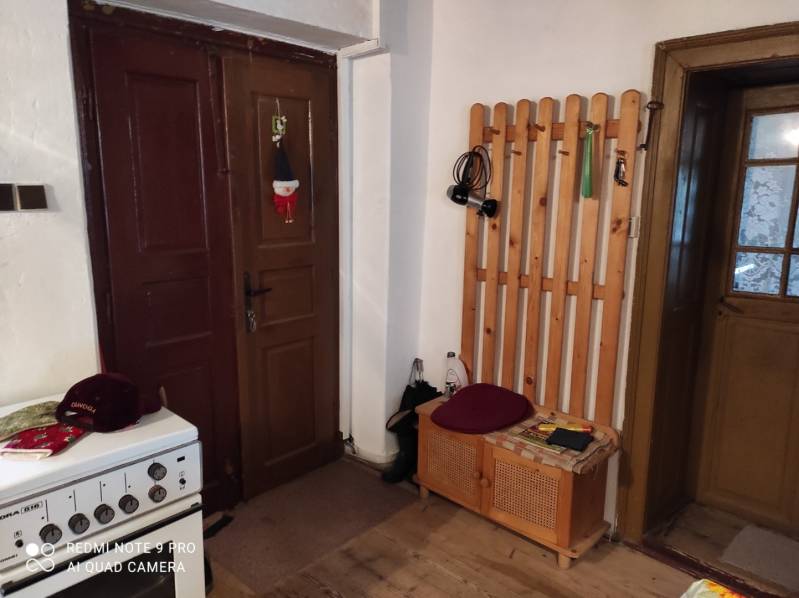 ČREMOŠNÉ-chalupa na pozemku 700m2   - Interiér rodinného domu s dverami, vešiakom a plynovým sporákom.