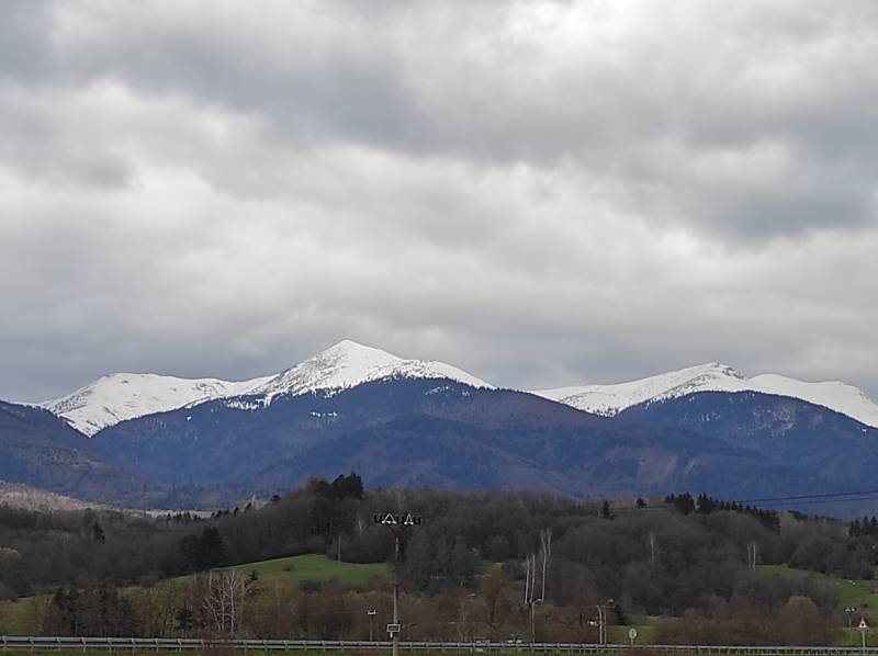 TURANY-veľký rekreačný pozemok v blízkosti časti TRUSALOVÁ 7667 m2 - Scénický výhľad na zasnežené pohorie a rekreačné pozemky pod oblačnou oblohou.