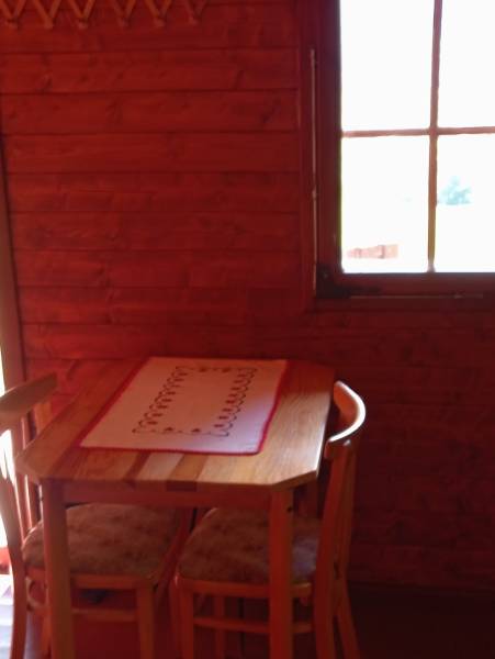 TURANY- krásna chata na pozemku 700m2 - Drevený stôl s dvoma stoličkami v útulnej chate na ulici Černík.