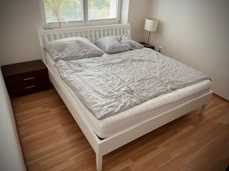 Slnečný 2i byt s balkónmi pri NC Nivy - Spálňa v 2-izbovom byte s podlahou s dreveným dekorom a dvojposteľou.