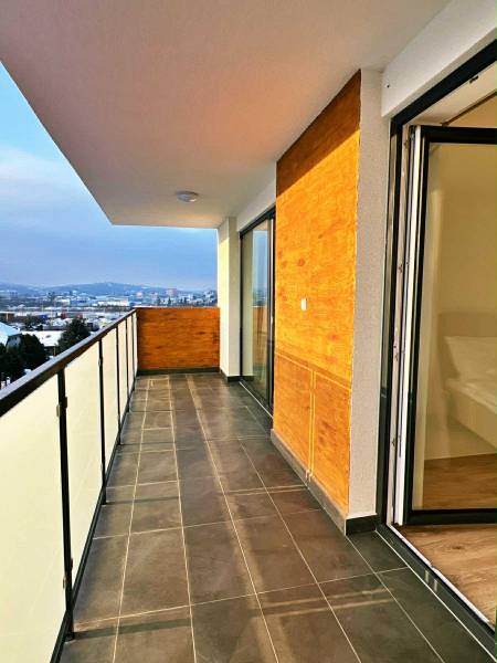 NADŠTANDARDNÝ 3-IZBOVÝ BYT NA PRENÁJOM | Byty Solivarská, Prešov - Balkón 3-izbového bytu s výhľadom na Prešov, Solivarská 14, veľké sklenené dvere.