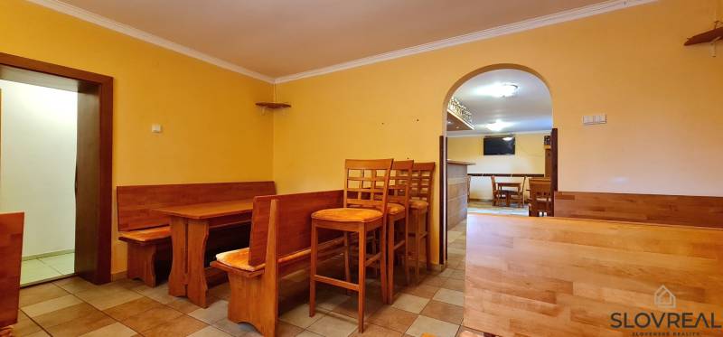 Predaj Domu v obci Lovča - Interiér rodinného domu s dreveným nábytkom, stoličkami a stolmi v príjemnom prostredí.