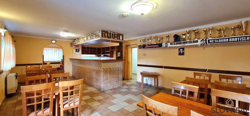 Predaj Domu v obci Lovča - Interiér rodinného domu so stolmi, barom a vystavenými trofejami.