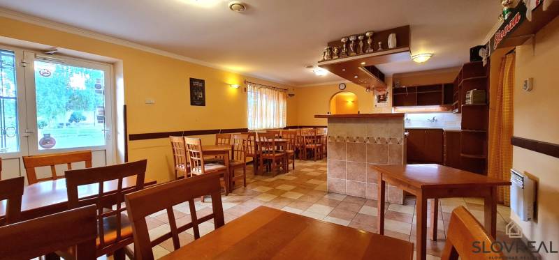 Predaj Domu v obci Lovča - Jedáleň s dreveným nábytkom a barovým pultom v rodinnom dome.