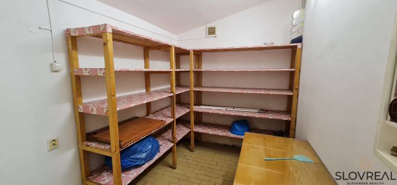 Predaj Domu v obci Lovča - Úložný priestor s policami a stolom v rodinnom dome.