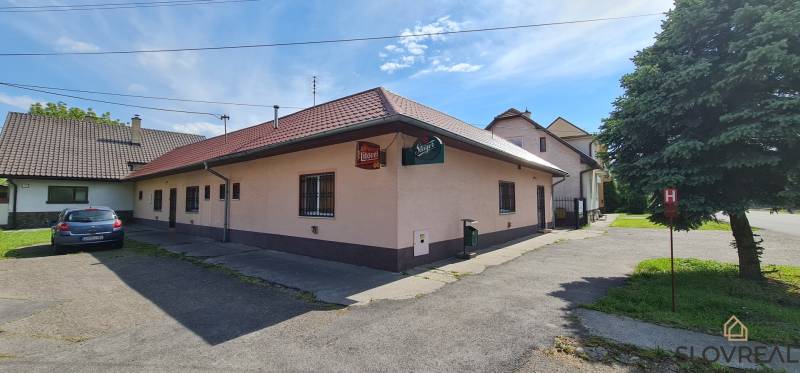 Predaj Domu v obci Lovča - Rodinný dom v Lovči s parkovaním a drevenými obkladmi, vedľa súkromného auta.