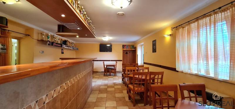 Predaj Domu (obchodného priestoru) v obci Lovča - Interiér rodinného domu s barovým pultom, stoličkami a dekoráciami na stene.