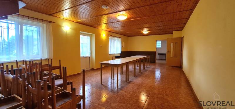 Predaj Domu (obchodného priestoru) v obci Lovča - Interiér rodinného domu s dreveným stropom, stoly a stoličky, veľké okná.