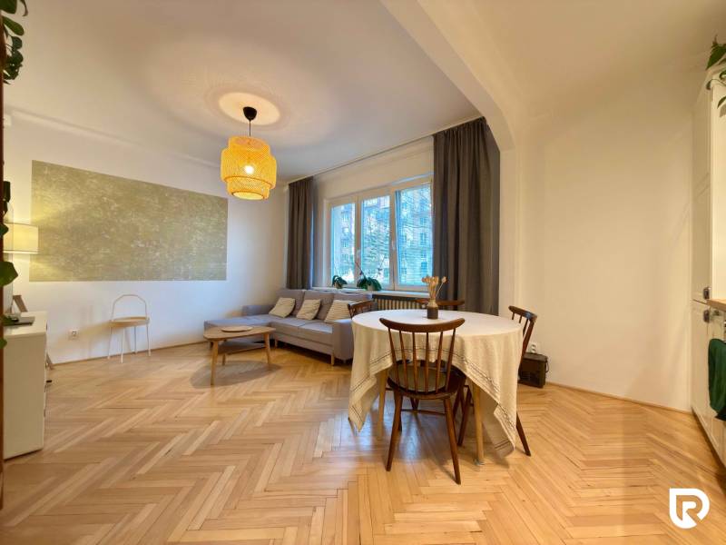 2-izbový byt 45m2 | Sklenárová - Ružinov - Obývacia izba v 2-izbovom byte s hnedou sedačkou a podlahou s dreveným dekorom.