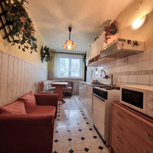 Predaj 3 - izbového bytu v Kuklove !!! - Kuchyňa v 3-izbovom byte s jedálenským kútom, pohovkou a vzorovanou podlahou.