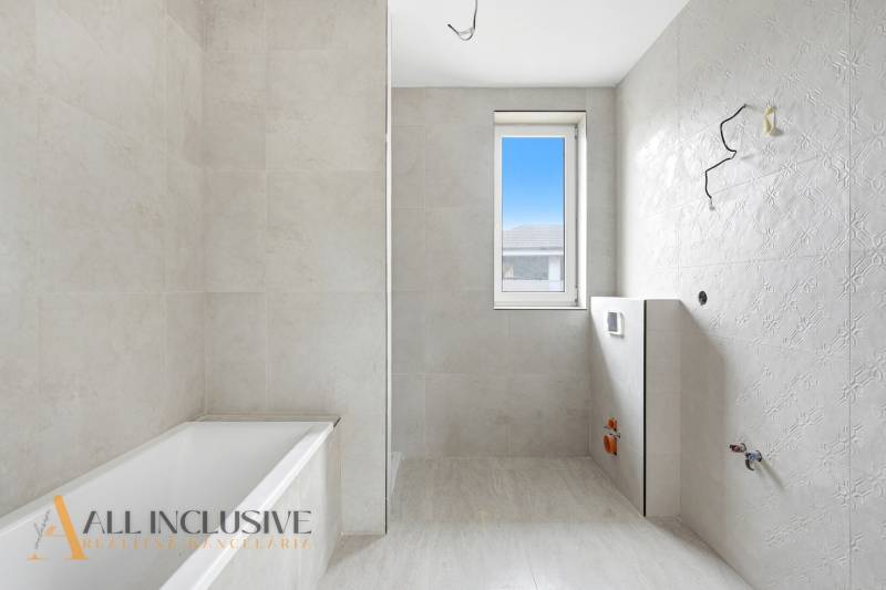 Na predaj 4-izbové novostavby, Veľká Paka - Kúpeľňa v rodinnom dome s vaňou, oknom a svetlými obkladmi.