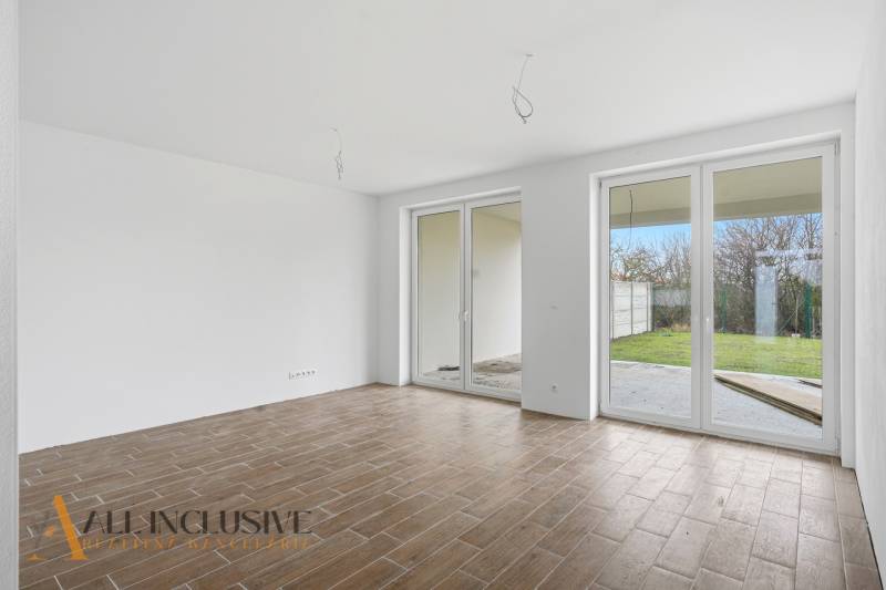 Na predaj 4-izbové novostavby, Veľká Paka - Izba v rodinnom dome s podlahou s dreveným dekorom a francúzskymi oknami.