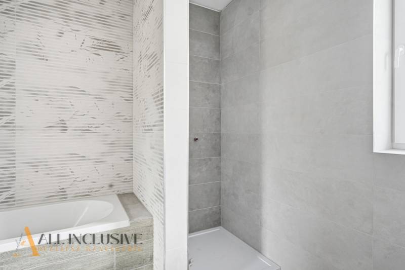 Na predaj 4-izbové novostavby, Veľká Paka - Kúpeľňa v rodinnom dome s vaňou a sprchovacím kútom, svetlé obklady.