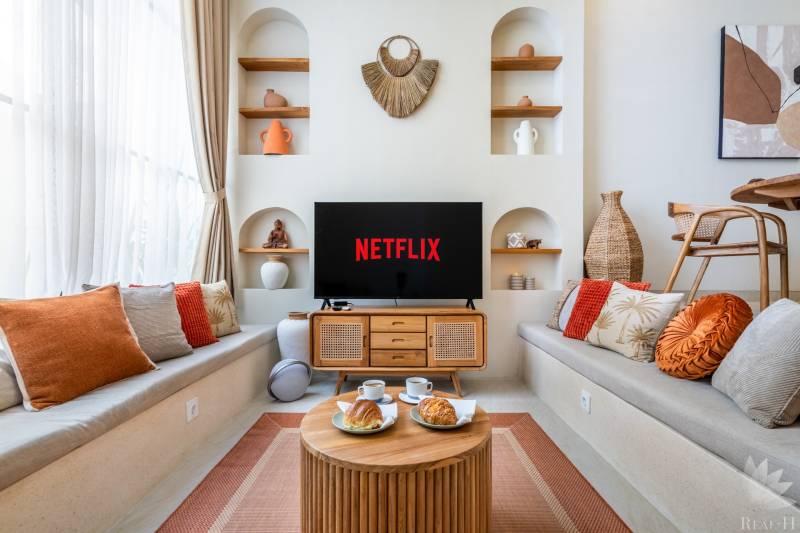 LUXUSNÁ 3-SPÁLŇOVÁ VILA S BAZÉNOM – CANGGU, BALI - Pohodlná obývačka vo vile s televízorom, vankúšmi a dekoráciami, podáva sa káva.