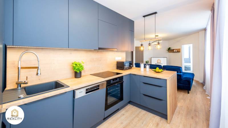 PRENÁJOM | 3i byt v centre Prešova | ZARIADENÝ - Kuchyňa v 3-izbovom byte s podlahou s dreveným dekorom a modrými skrinkami.
