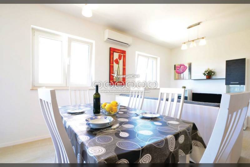 PRIVLAKA - BYT S4- dvojizbový byt 63,42 m2 vzdialený 150 m od mora - Jedálenský kút v 2-izbovom byte s prestretým stolom a dekoráciami na stene.