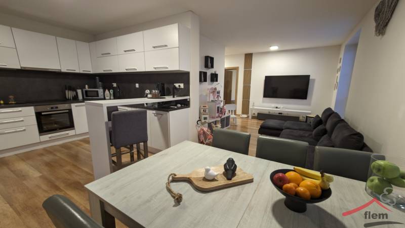 2-izbový byt na predaj, Vráble – sídl. Lúky, 56 m2 - Kuchyňa s obývačkou v 2-izbovom byte, svetlá linka, podlaha s dreveným dekorom.